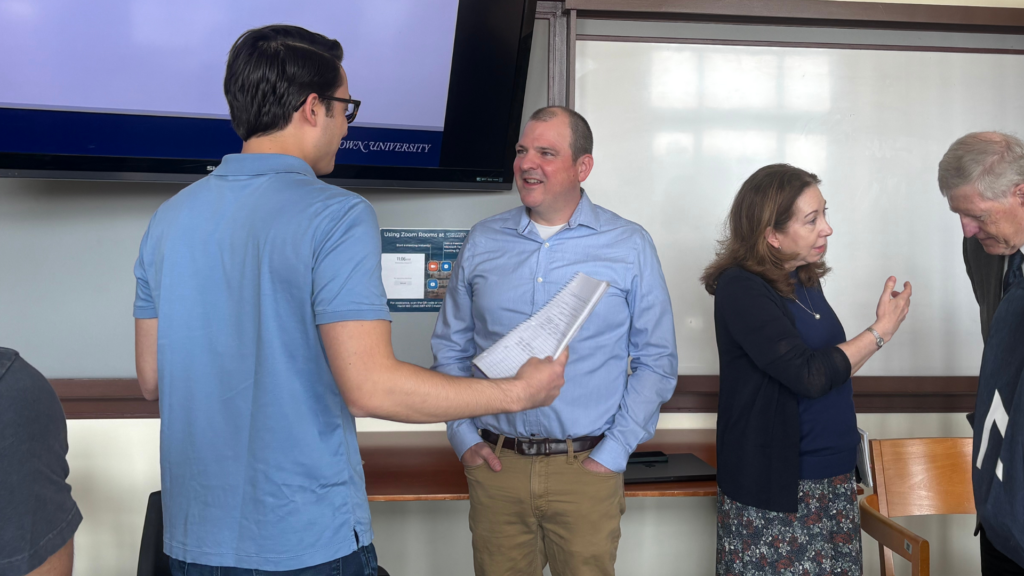 Tim DeStefano and two men and a woman conversing.