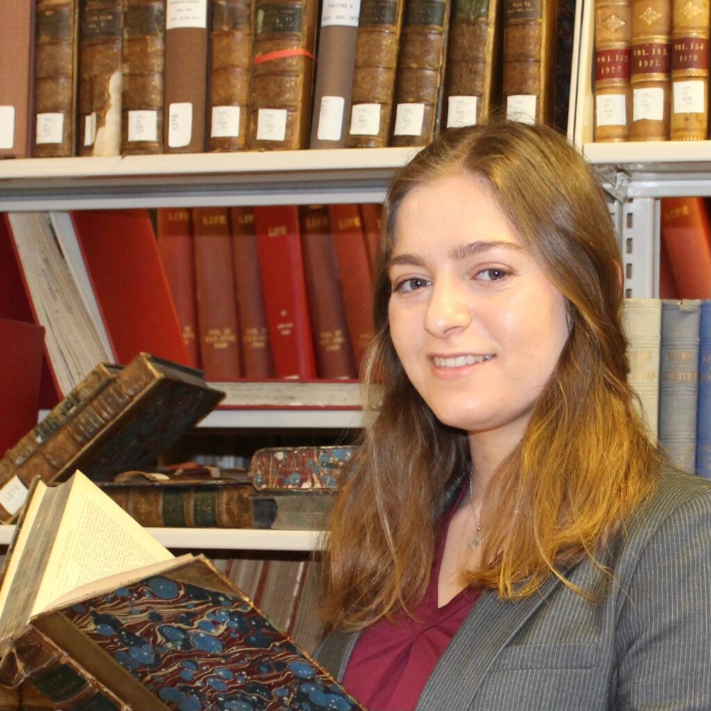 Shir Bloch smiling while holding a book.